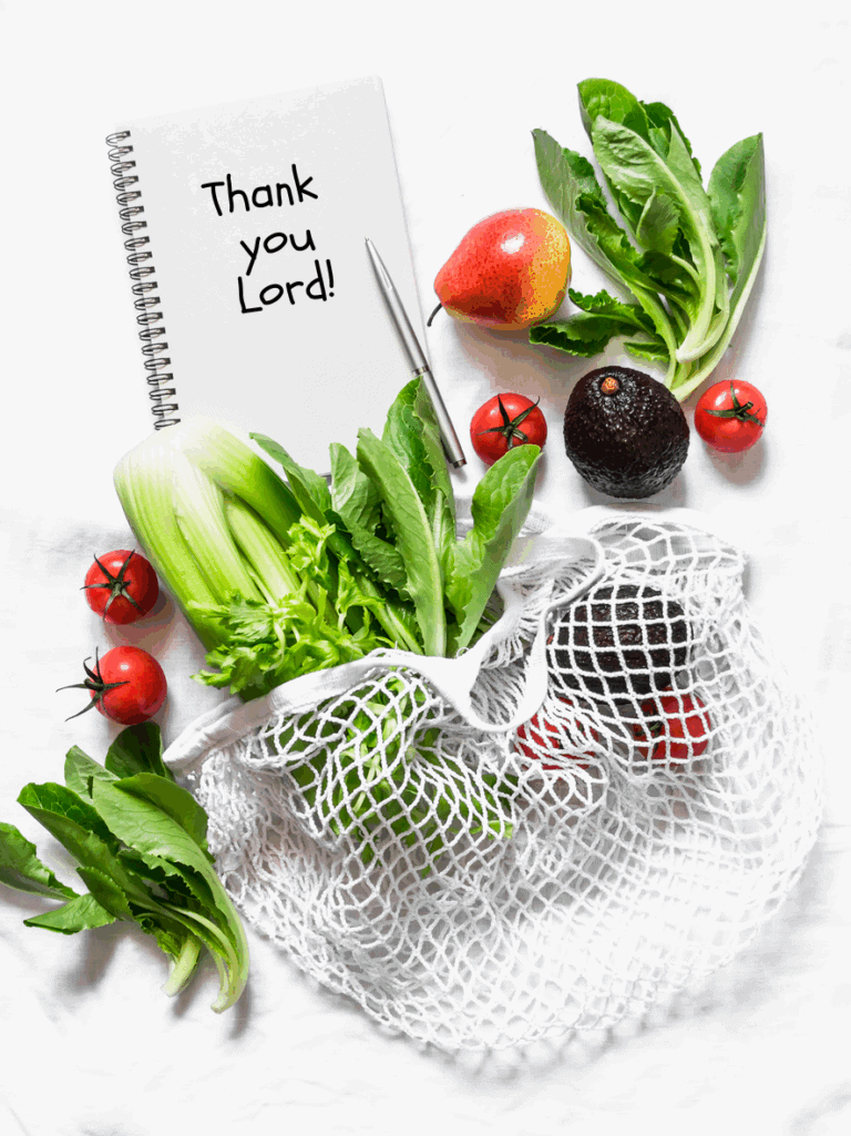 greens, vegetables, fruit in a shopping bag on a white countertop with note that says thank you lord.