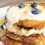 flower plate with 3 pumpkin pancakes on it.