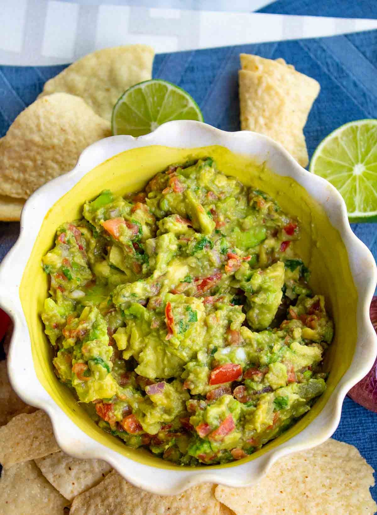 decorative white and yellow bowl filled with chunky guacamole.