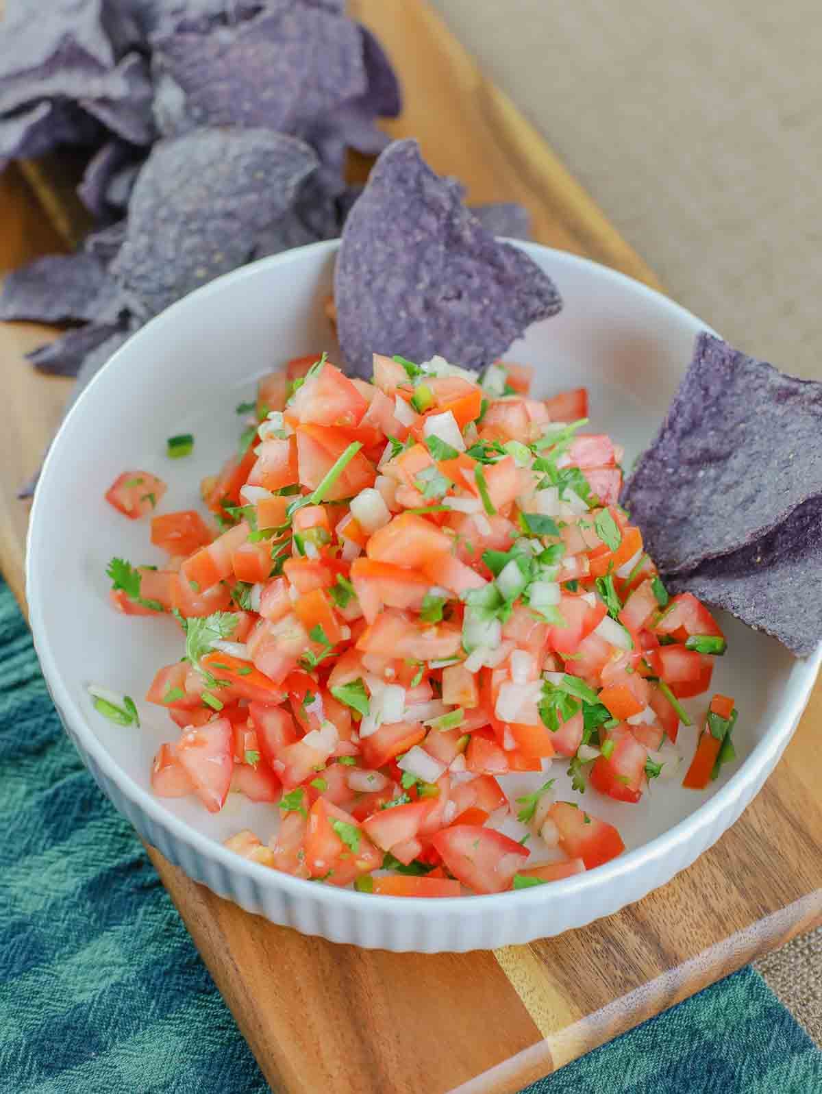 close up of a bowl full of homemade pico de gallo and chips.