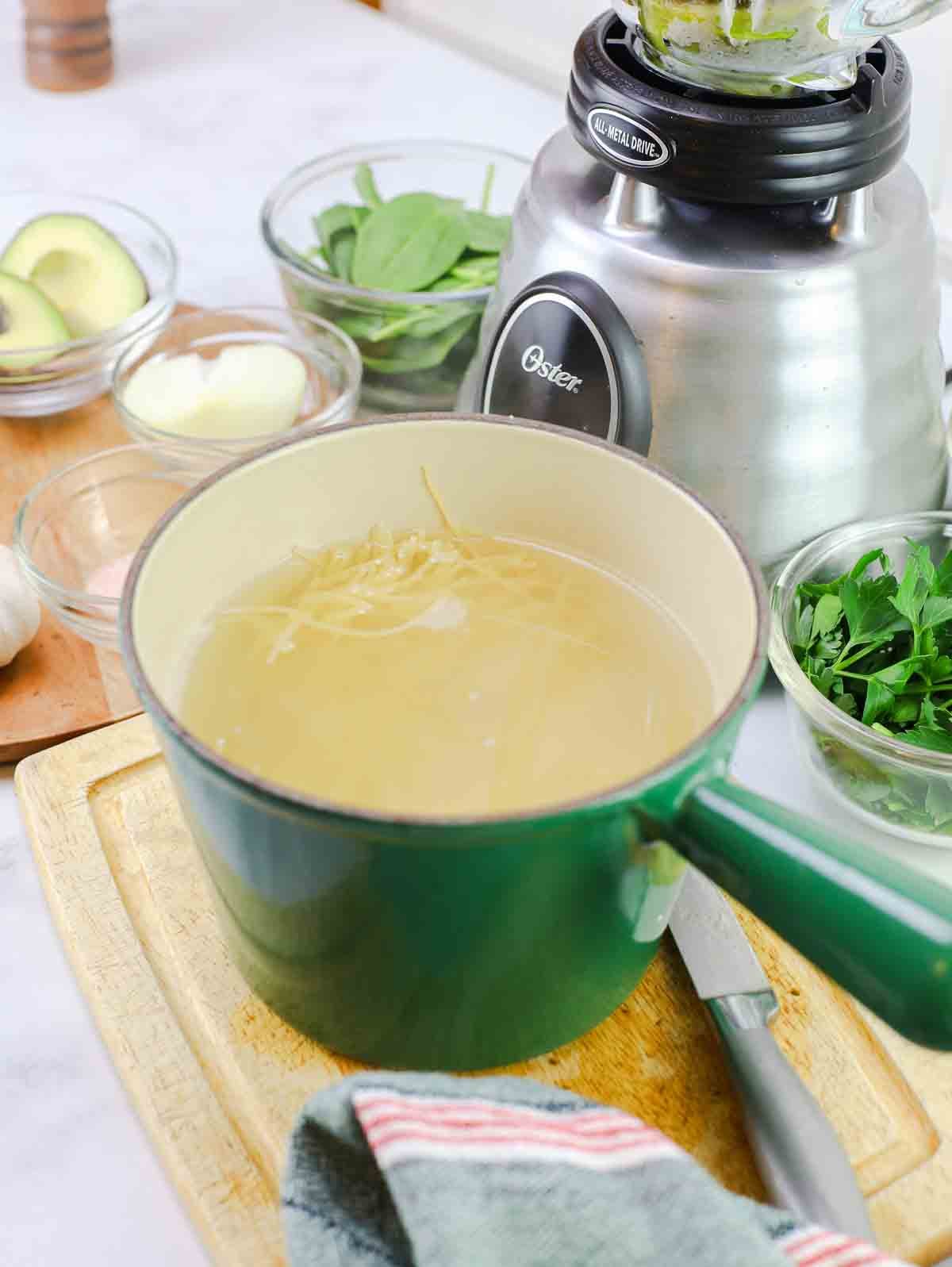 green stockpot with boiling spaghetti.
