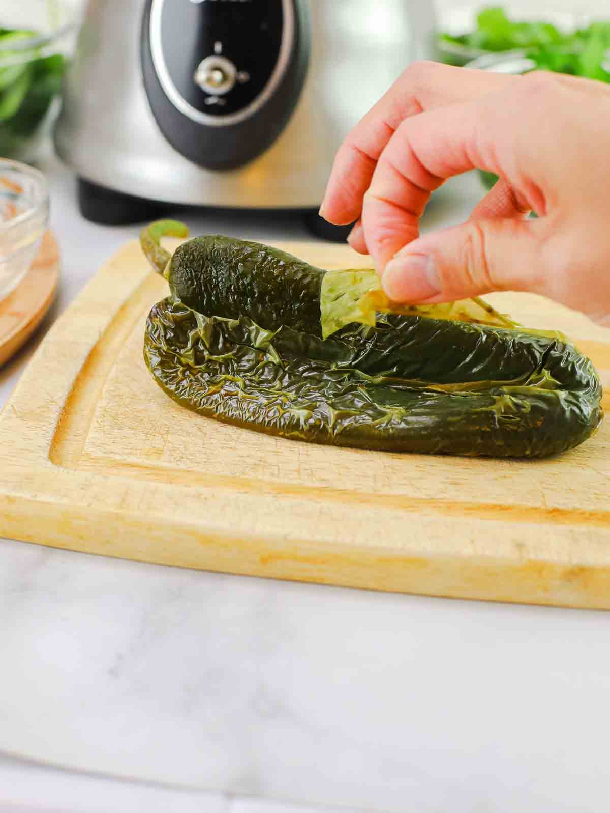 roasted poblano pepper being peeled.