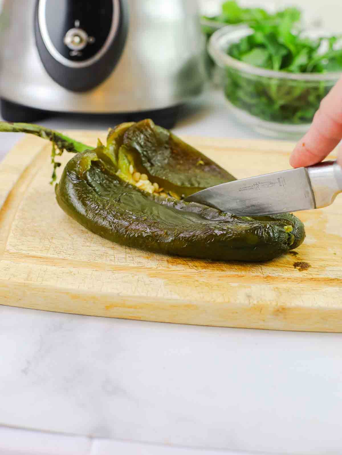 slicing a roasted poblano chili.