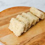 slices of battered and breaded extra cripsy panko tofu on a cutting board.