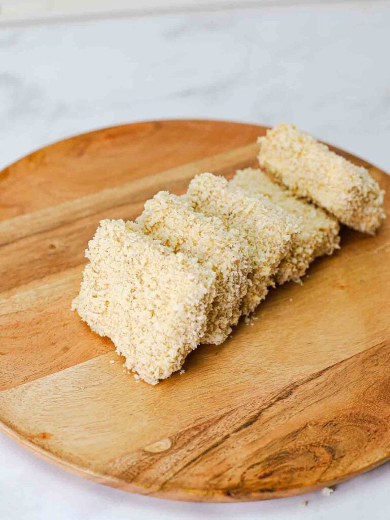 slices of battered and breaded extra cripsy panko tofu on a cutting board.