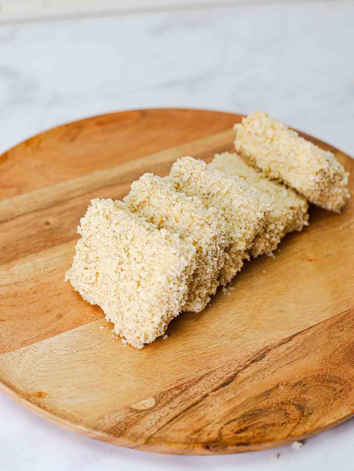 slices of battered and breaded extra cripsy panko tofu on a cutting board.