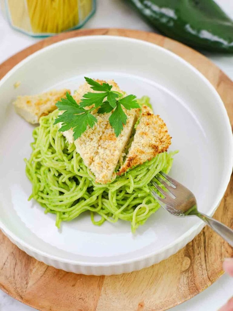 espagueti verde on a white plate topped with crispy panko tofu.