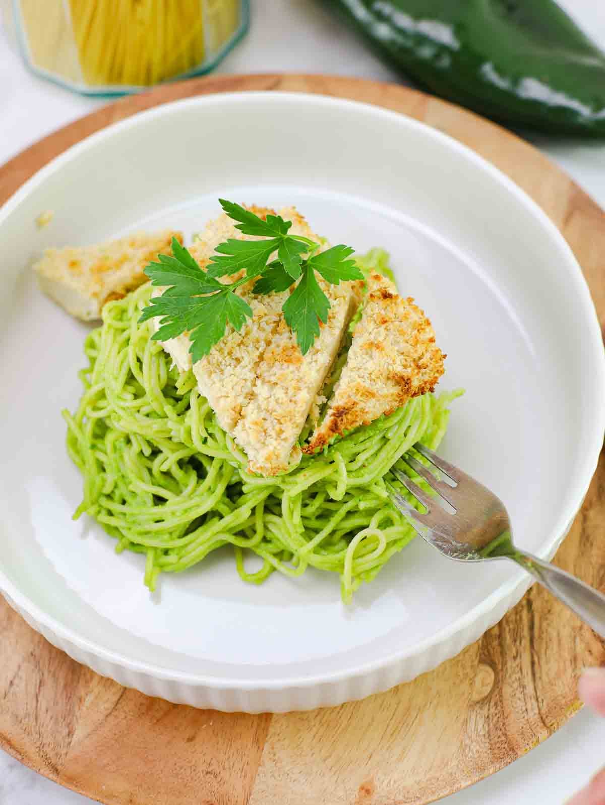 espagueti verde on a white plate topped with crispy panko tofu.
