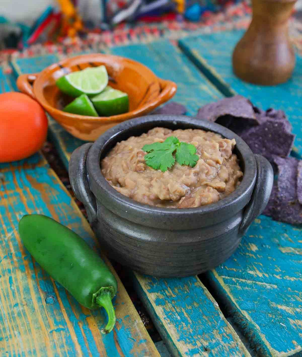 homemade refried beans in a black crock.