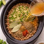 crock pot with dry pinto beans, broth, and seasonings.