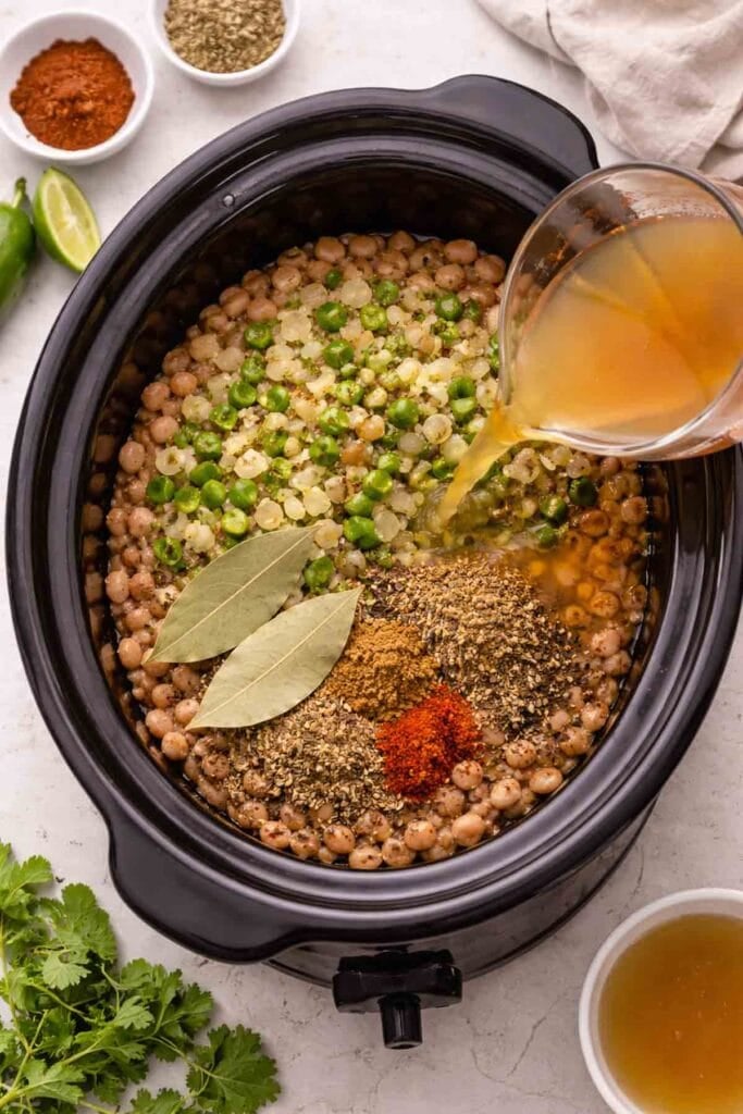 crock pot with dry pinto beans, broth, and seasonings.