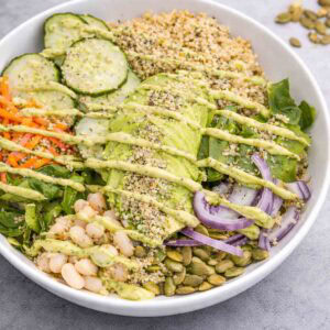 overhead shot of protein veggie bowl drizzled with avocado dressing.