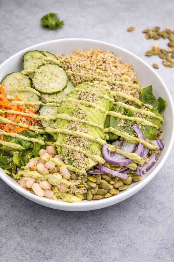 overhead shot of protein veggie bowl drizzled with avocado dressing.