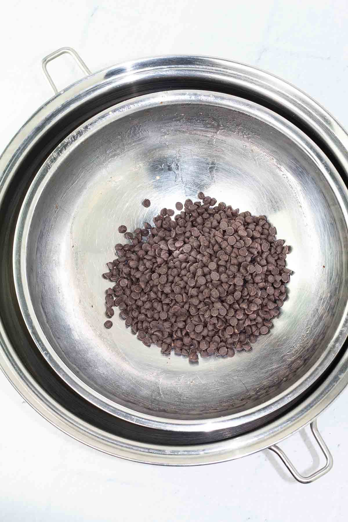 round pot with a stainless mixing bowl with chocolate chips.