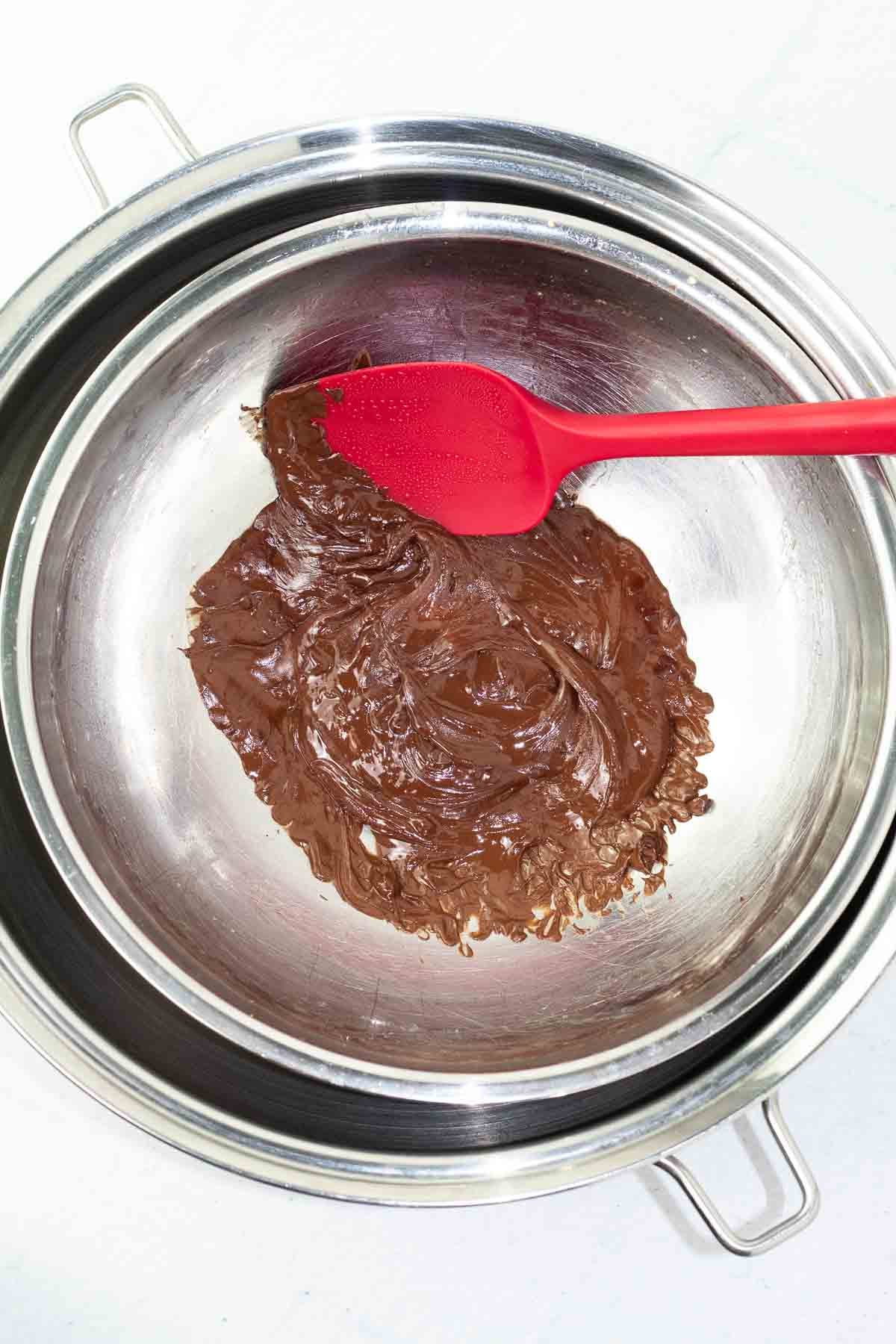 pan with melted chocolate chips and red spatula.