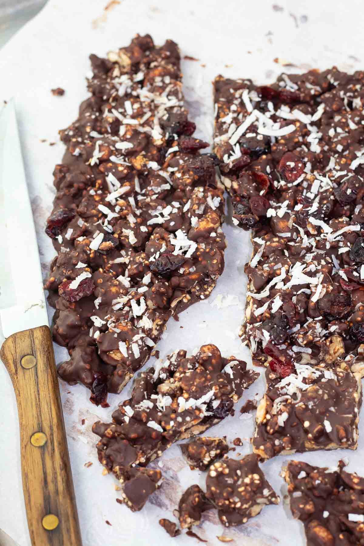 chocolate bark broken into pieces with a knife beside.