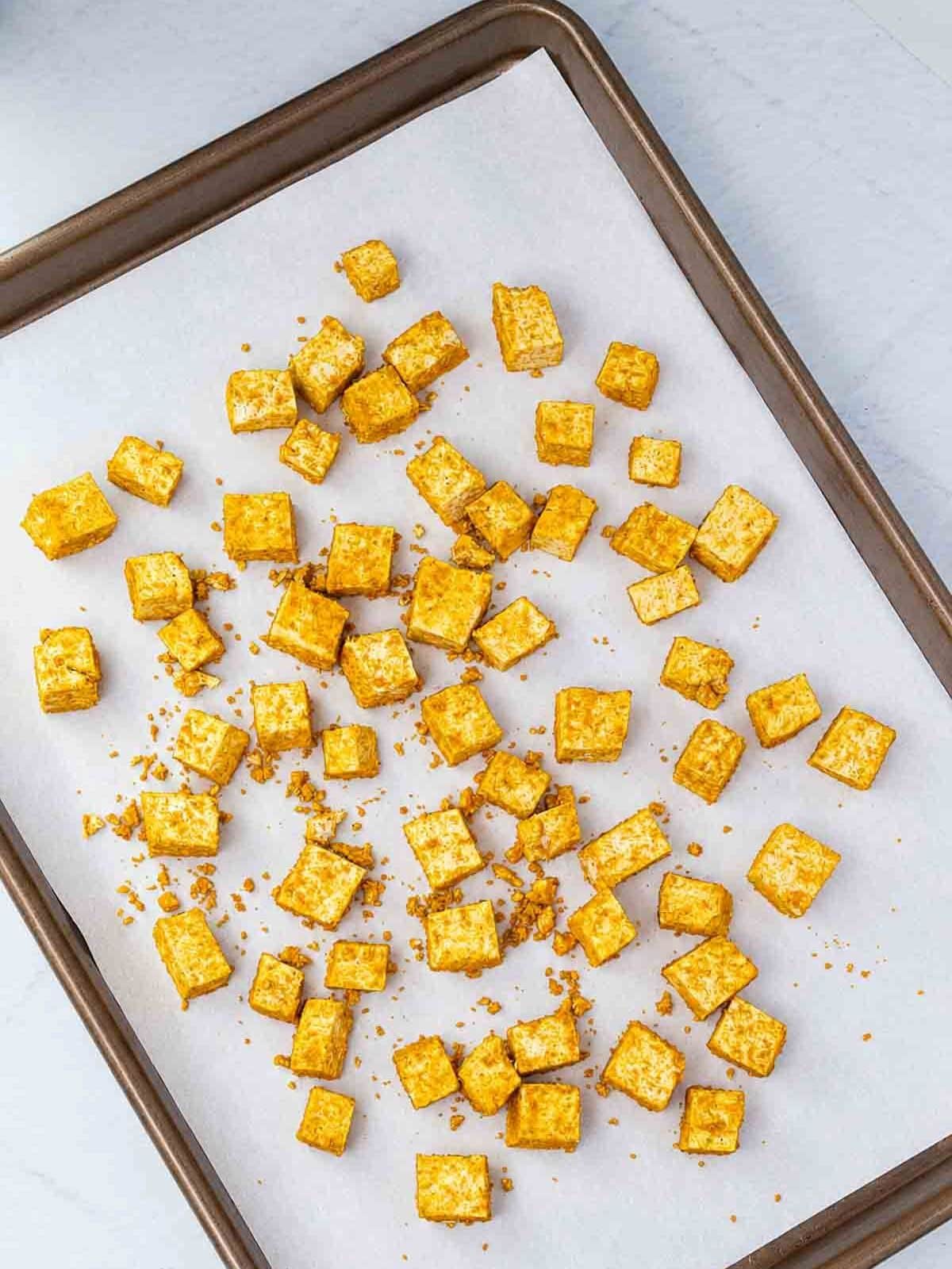 curry seasoned tofu on a baking sheet.