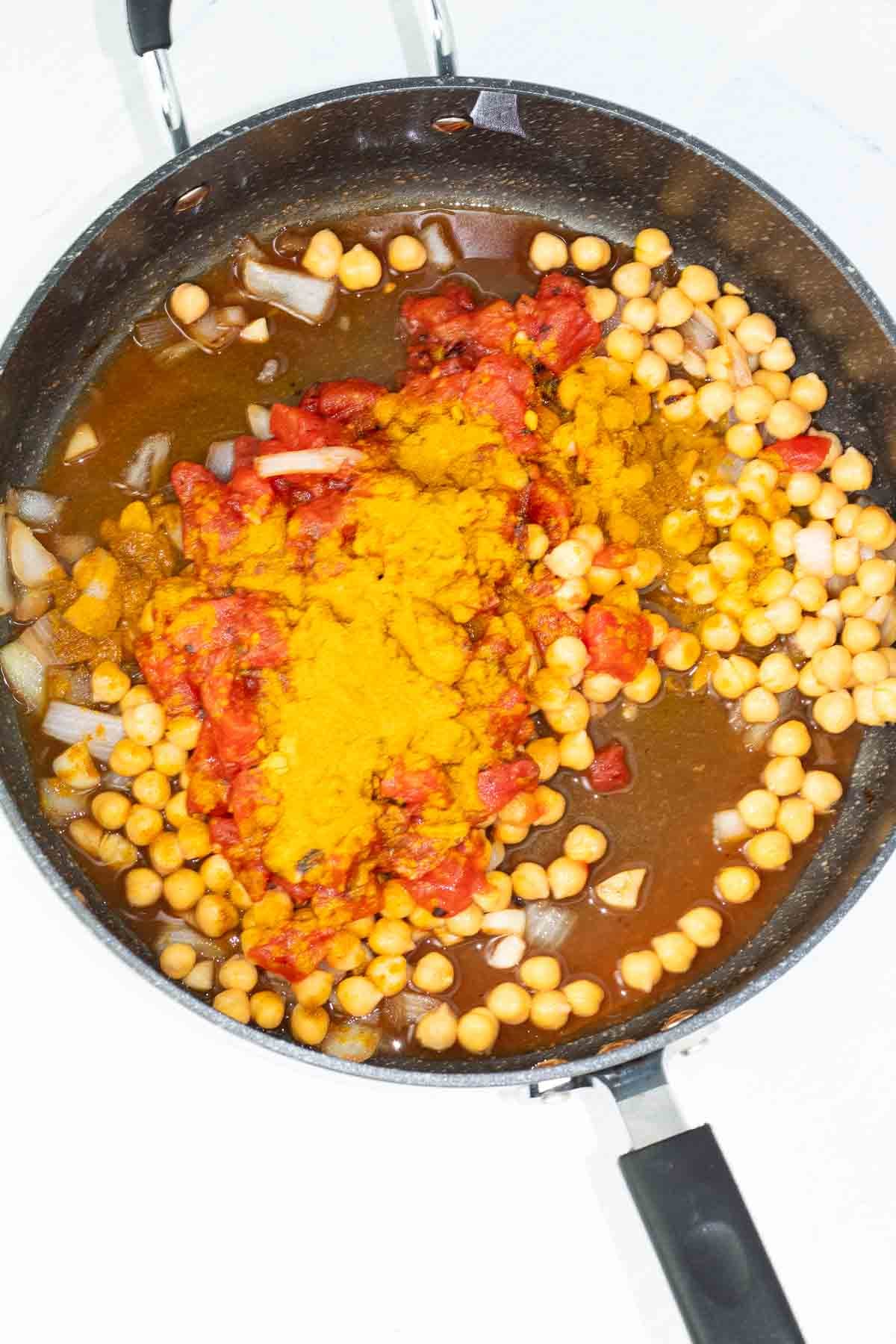 frying pan with ingredients for chickpea tofu curry.