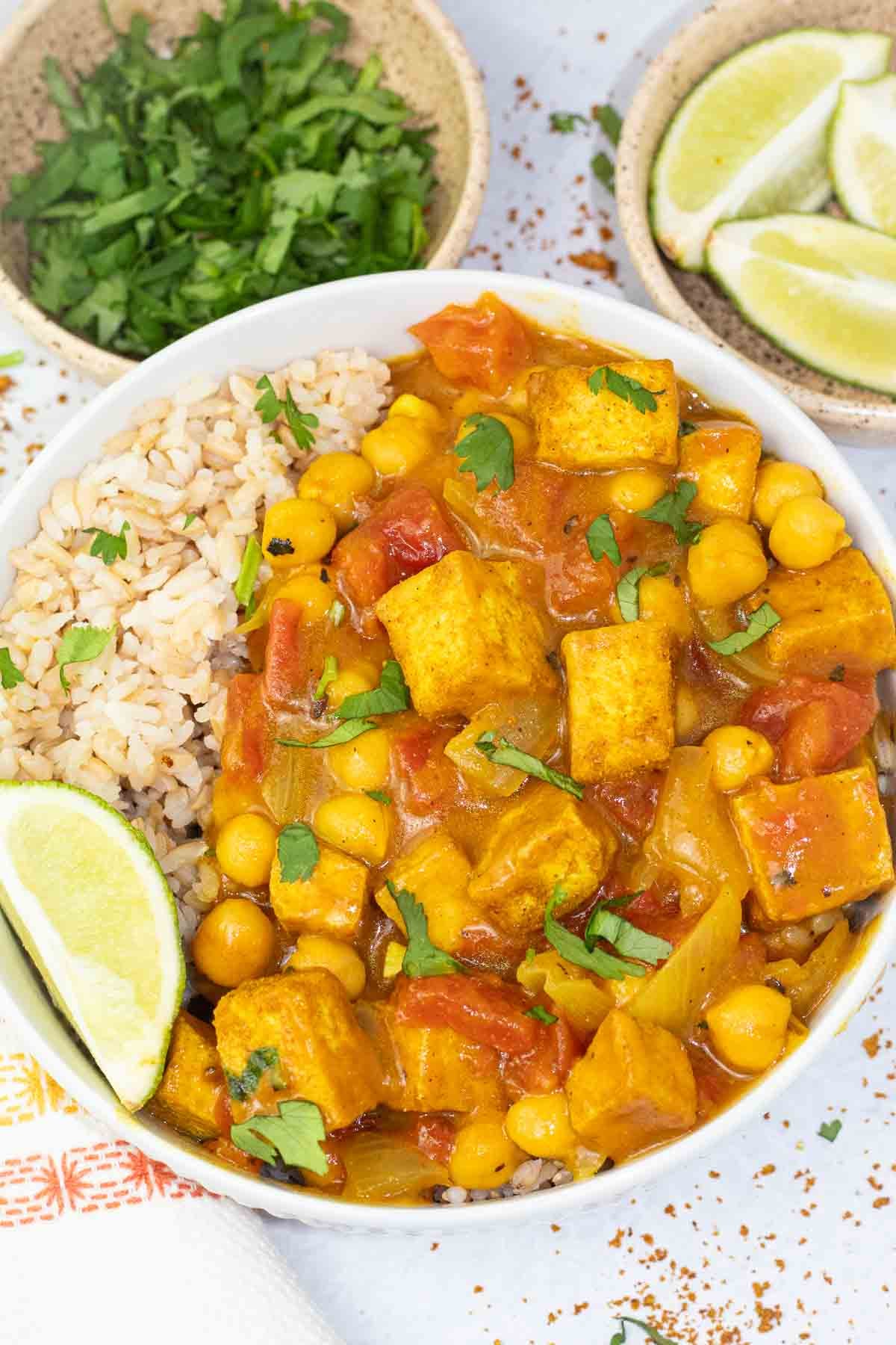 tofu chickpea curry in a white bowl topped with cilantro.
