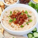 white bean dip with sundried tomatoes in a bowl.
