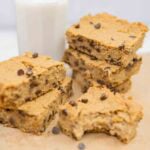 stacks of chickpea blondies with a glass of plant milk in background.