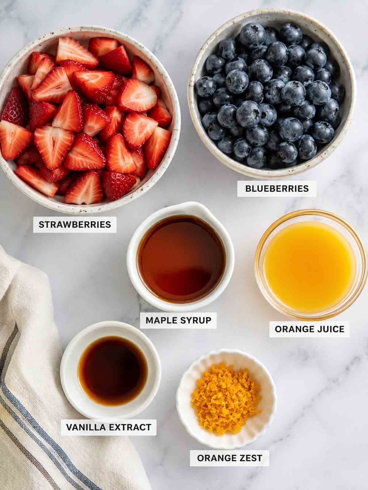 ingredients photo for macerated strawberries that includes maple syrup, orange juice, orange zest, and vanilla extract.