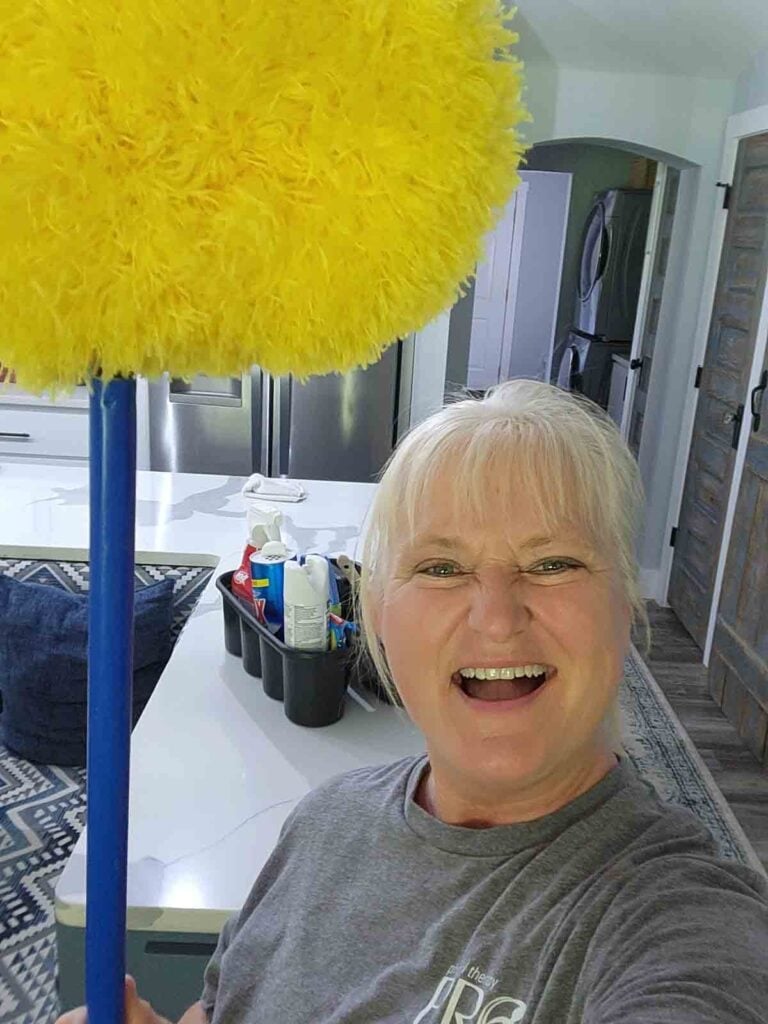 terri praise cleaning with her ceiling fan duster.