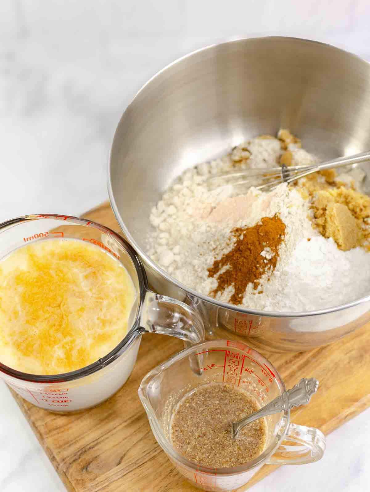flax egg in measuring cup beside bowl with flour and another bowl with waffle ingredients.