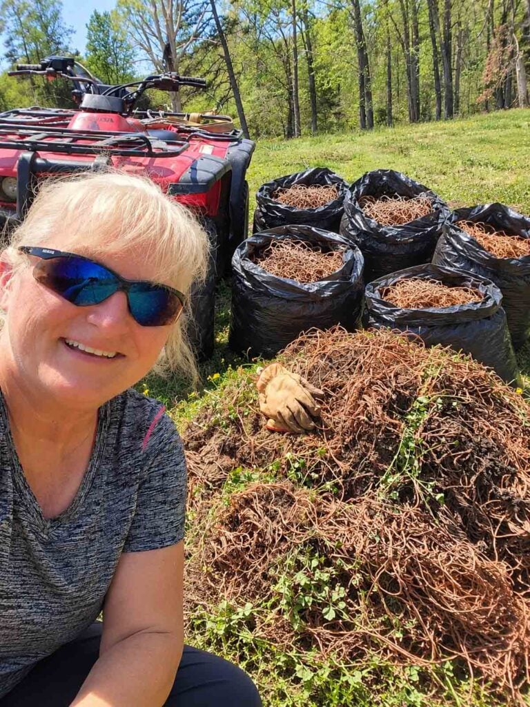 terri in field with four-wheeler and bags of hay bale twine.