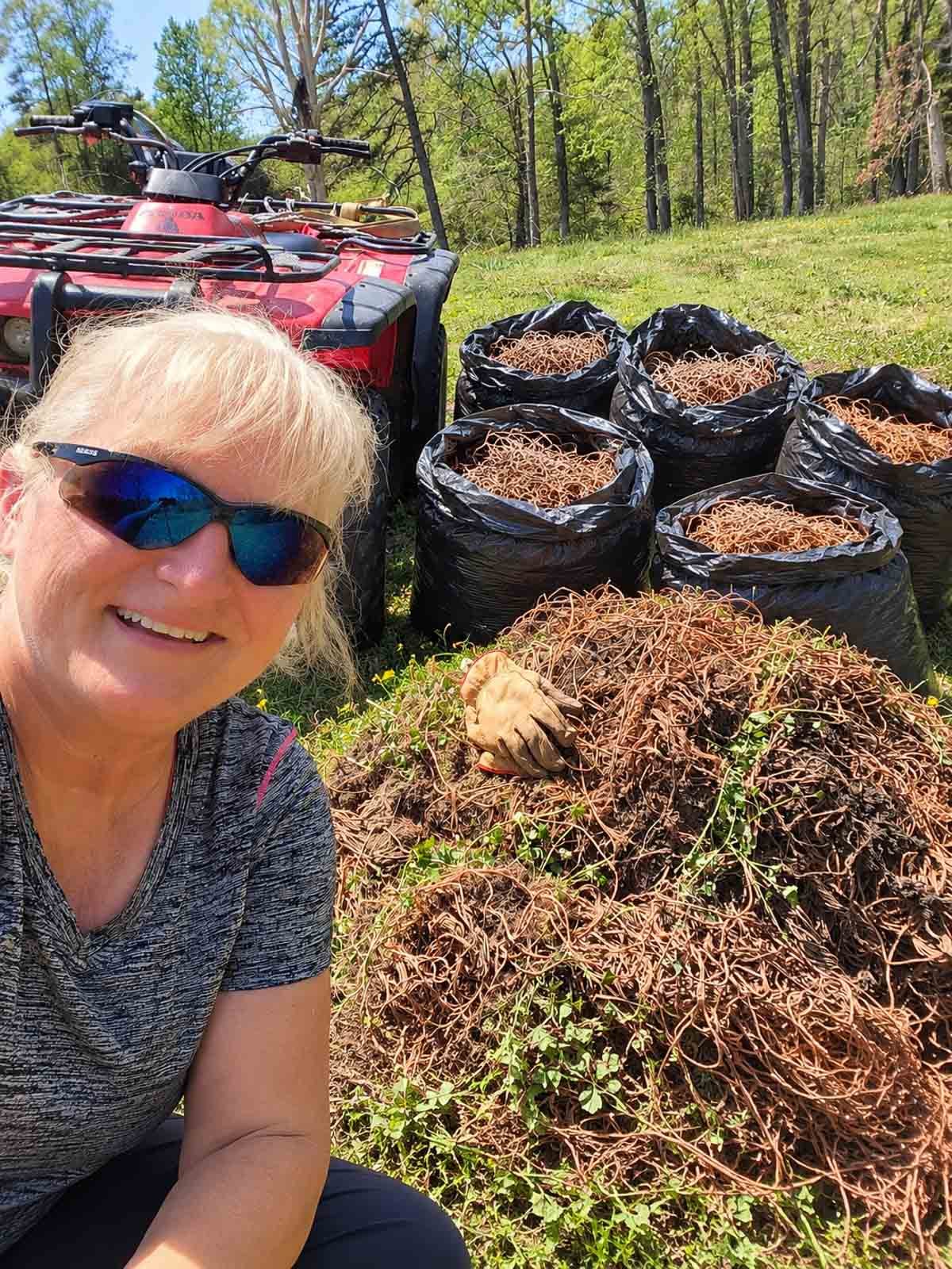 terri in field with four-wheeler and bags of hay bale twine.