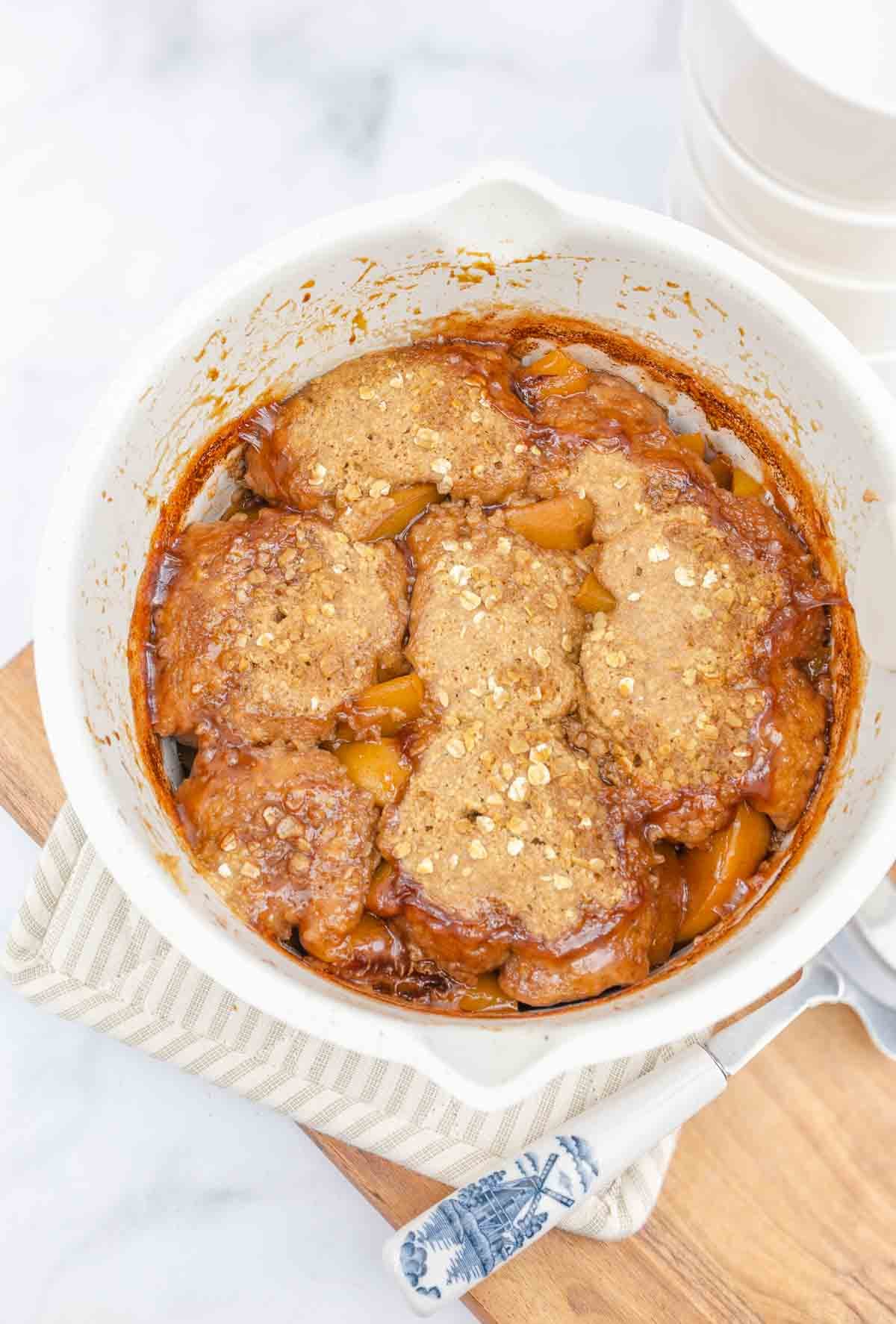 peach cobbler just taken from the oven and sitting on a pot holder.